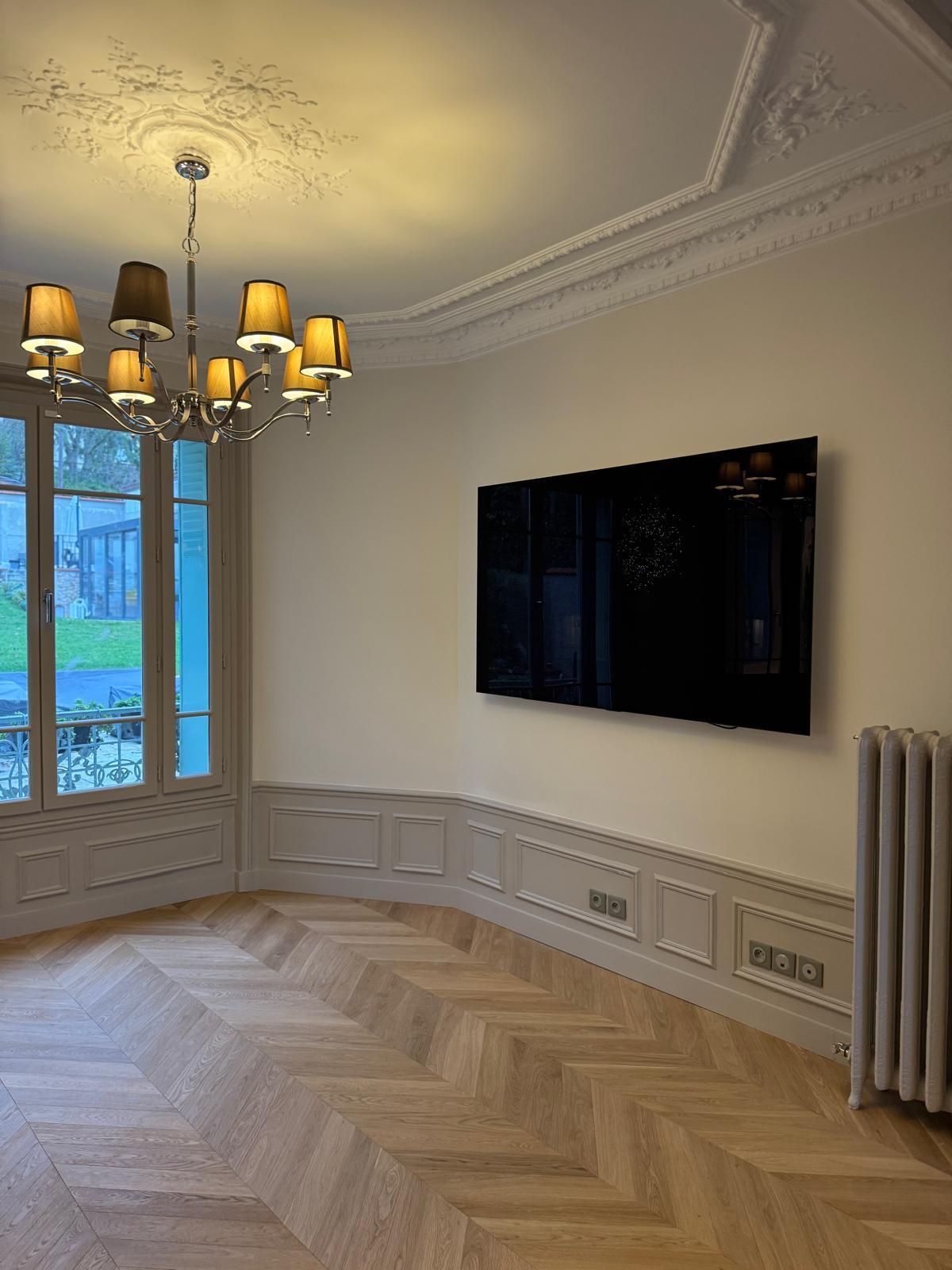 Angle du séjour : moulures, soubassements, télévision et parquet