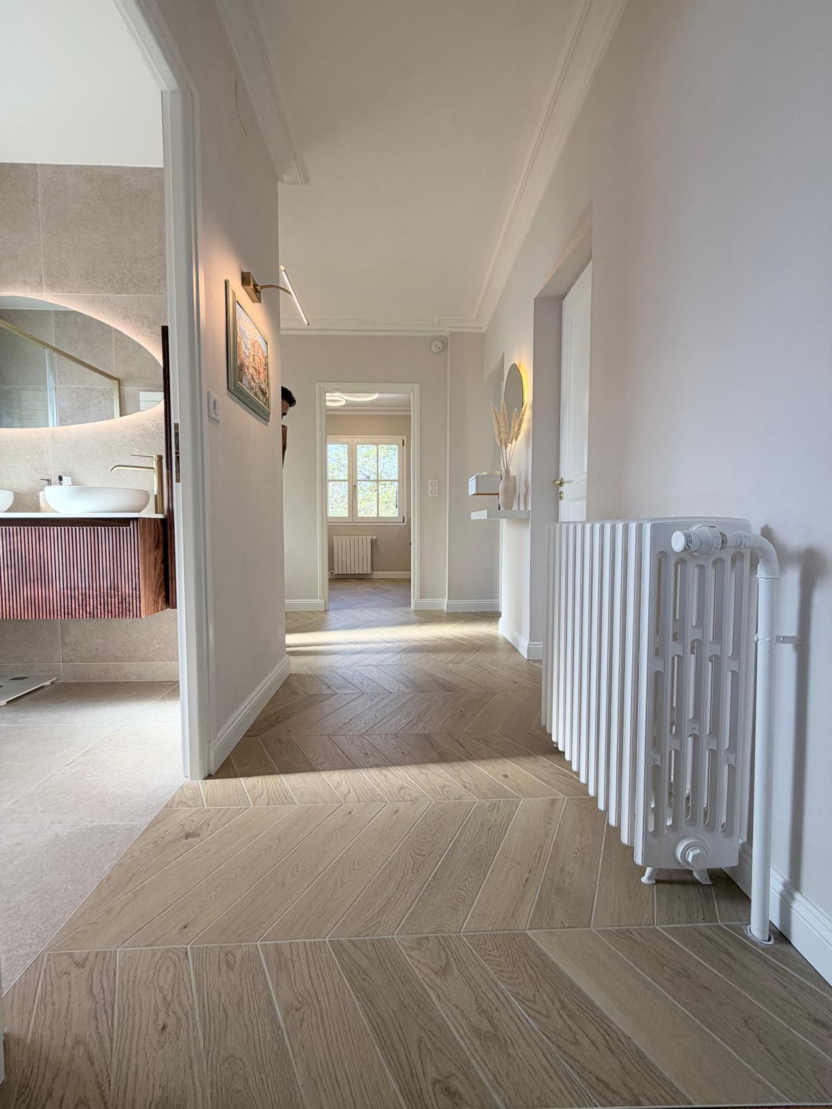 Couloir avec radiateur en fonte et entrée de la salle de bain