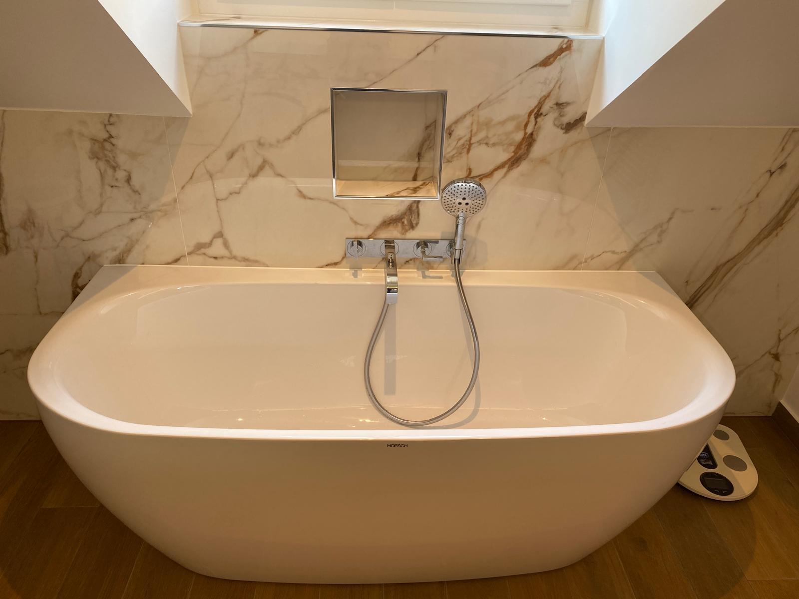 Baignoire îlot blanche et mur effet marbre