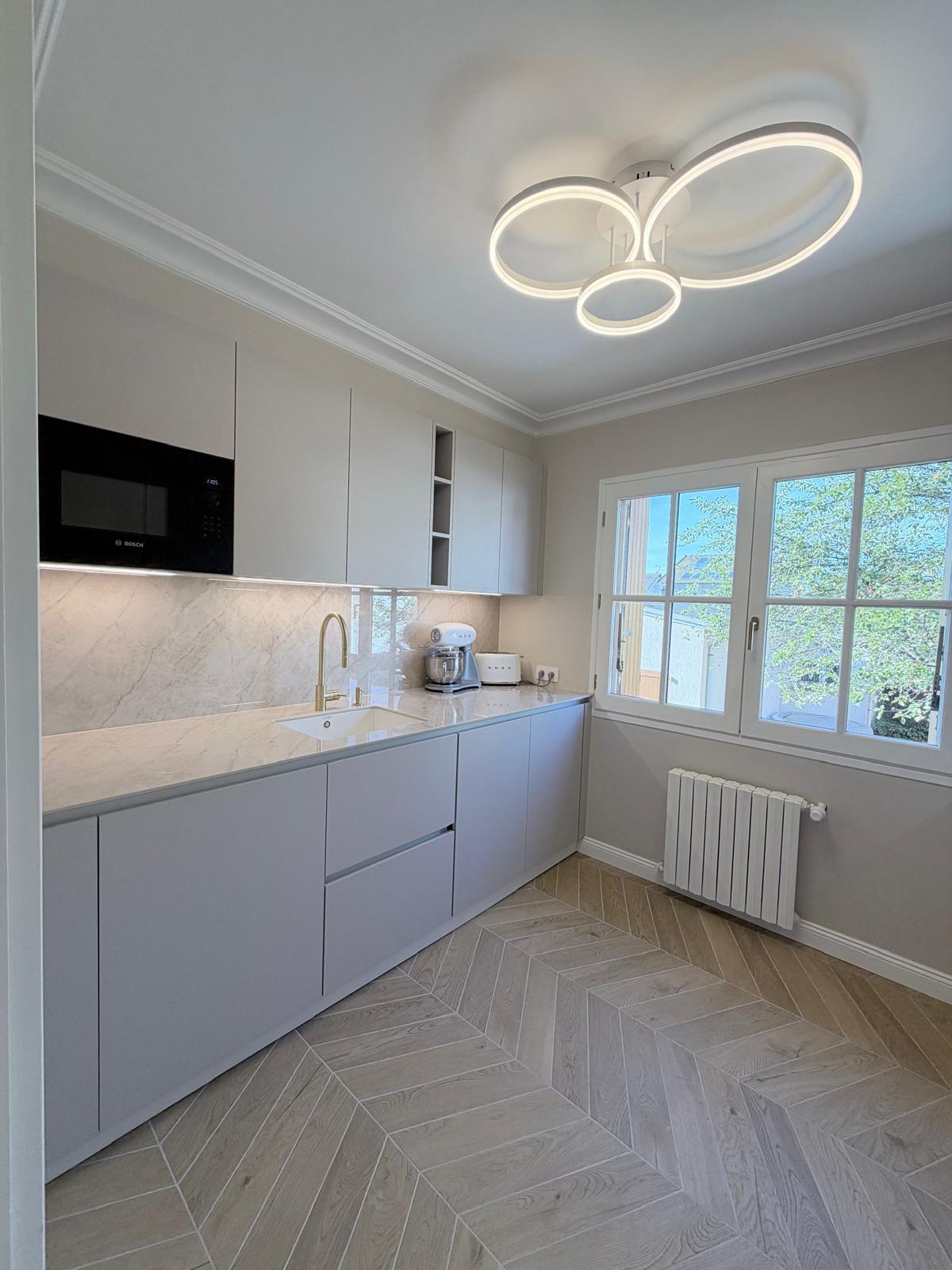 Cuisine gris clair, plan effet marbre et sol en chevron