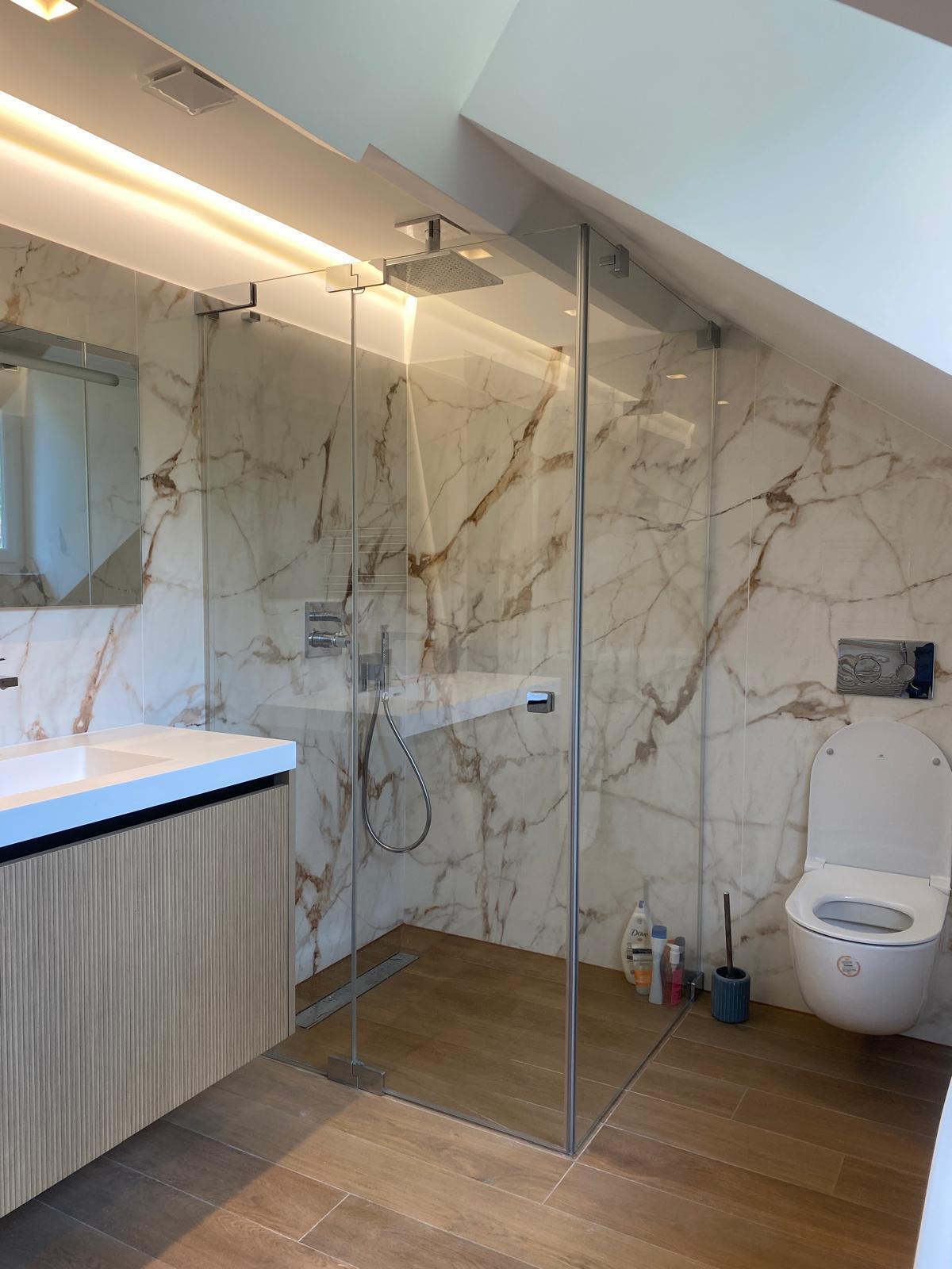 Salle de bain : douche vitrée, vasque et carrelage effet marbre